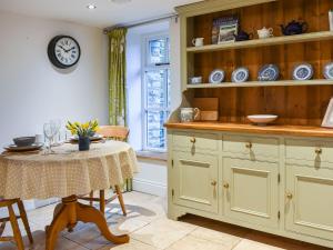 The Hayloft - Uk37563 في Crosby Garrett: مطبخ مع طاولة وساعة على الحائط +5 صور