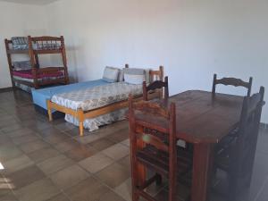 伊塔尼亚恩Loft Praia do Sonho的一间有床、桌子和椅子的房间