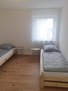 Un dormitorio con dos camas y una ventana. en Zimmer-Leutkirch, en Leutkirch im Allgäu 3 fotos más