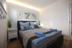 a bedroom with a bed with blue towels on it at Fewo Wellenklang Hainer See bei Leipzig in Neukieritzsch