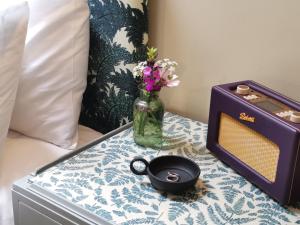 einen Tisch mit einer Blumenvase und einem Radio in der Unterkunft The Butterchurn - Uk50805 in Cratfield + 2 Fotos