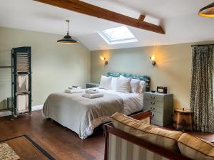 ein Schlafzimmer mit einem Bett und einer Couch in der Unterkunft The Butterchurn - Uk50805 in Cratfield