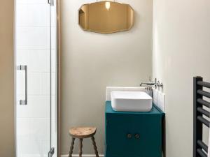 ein Badezimmer mit einem blauen Schrank und einem Waschbecken in der Unterkunft The Butterchurn - Uk50805 in Cratfield