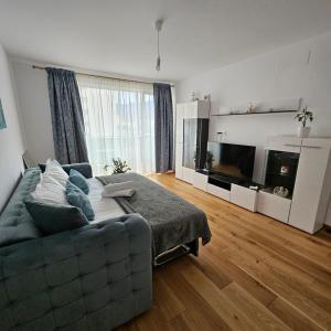 a living room with a couch and a flat screen tv at FourSeasons Residence in Braşov