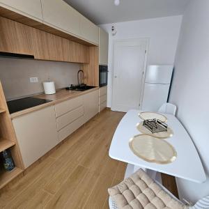 a kitchen with a white table and a white refrigerator at FourSeasons Residence in Braşov +3 photos