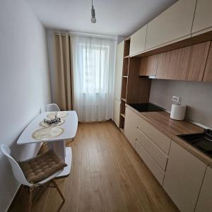 a small kitchen with a white table and a white chair at FourSeasons Residence in Braşov