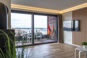 a living room with a sliding glass door with a balcony at Fewo Wellenklang Hainer See bei Leipzig in Neukieritzsch