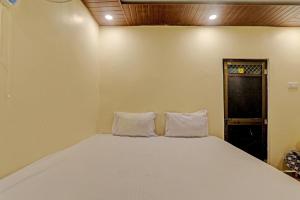 een slaapkamer met een bed met twee kussens erop bij Hotel O Home Shyama Lodge in Ayodhya