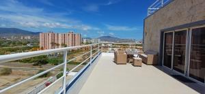 een balkon met stoelen en uitzicht op de stad bij Chillis Penthouse in Porlamar