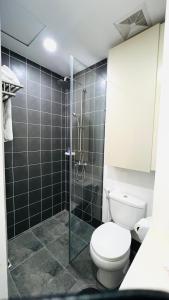 une salle de bains avec toilettes et douche en verre dans l'établissement AMANI GRAND CITYGATE STUDIO by ADORE IT, à Davao