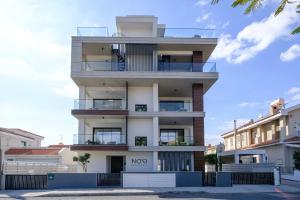 リマソールにあるNoir Luxury Residences by Nomadsの「移転」と書かれた看板のある背の高い白い建物