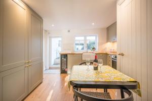 een keuken met een tafel met twee wijnglazen erop bij Pink Cottage in Leiston +6 foto's