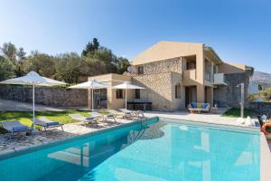 a villa with a swimming pool and a house at Three Stones Villas by Rodostamo Collection in Kassiopi