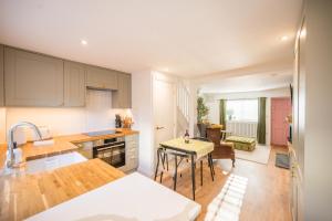 een keuken met een wastafel en een tafel. bij Pink Cottage in Leiston