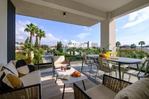 a patio with tables and chairs on a balcony at Noir Luxury Residences by Nomads in Limassol