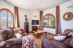 een woonkamer met twee banken en een tafel bij Villa Sabine - PlusHolidays in Calpe