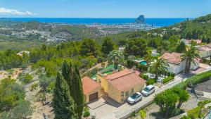 een luchtzicht op een huis met palmbomen en de oceaan bij Villa Sabine - PlusHolidays in Calpe