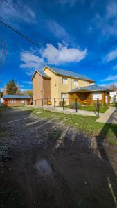 um edifício com uma cerca na frente em Apartamentos Matices em El Calafate