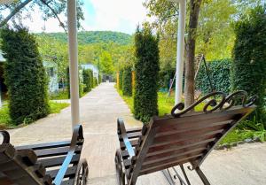 a wooden bench sitting on a porch with a swing at Church-View Lodge by Green Garden, Dilijan in Dilijan