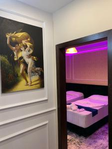 Pokój z obrazem na ścianie obok łóżka w obiekcie Hotel Sanremo w Tiranie