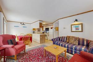 a living room with a couch and chairs and a kitchen at Slopeside 4001 in Jay
