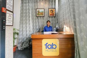 uma mulher sentada numa secretária num quarto de hotel em FabHotel Gazelle Inn em Gurgaon