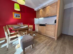 a kitchen with a wooden table and a dining room at Résidence Christiana 406 Clés Blanches Courchevel in La Tania