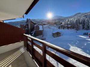 a balcony with a view of a snow covered mountain at Résidence Christiana 406 Clés Blanches Courchevel in La Tania +7 photos