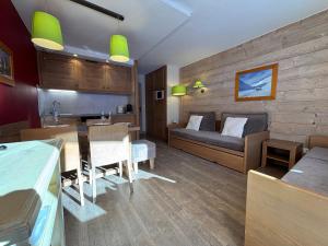 a living room with a bed and a dining room at Résidence Christiana 406 Clés Blanches Courchevel in La Tania