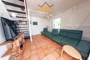 a living room with a couch and a tv at La Villa du soleil in Les Trois-Îlets