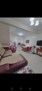 una camera da letto con due letti e un soggiorno con sedie rosse di Janice Place a Marilao