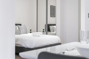 a white bedroom with a bed and a mirror at Contemporary Studio near NEC & Airport Free Parking in Olton