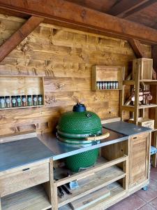 a kitchen in a wooden cabin with a green pot at Chata Bella in Mýto pod Ďumbierom +24 photos