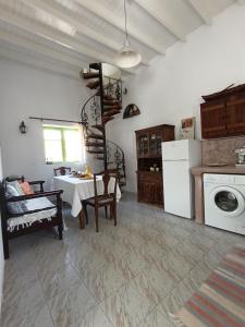 a kitchen with a table and a staircase in a room at Aegaia Residencies in Katapola +22 photos