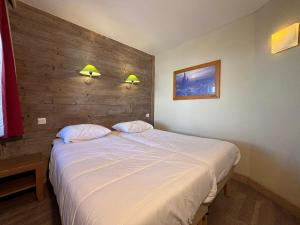 谷雪维尔Résidence Christiana 408 Clés Blanches Courchevel的卧室里有一张白色的大床，上面有两个枕头