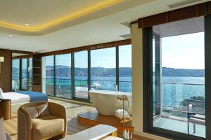 a hotel room with a tub and a view of the water at Çırağan Hotel Bosphorus in Istanbul