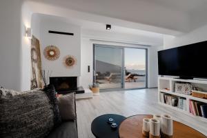 a living room with a couch and a tv and a table at Villa Anamnesia, Stelida Naxos in Stelida