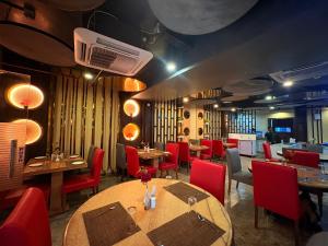 a restaurant with wooden tables and red chairs at Rooftop Sea View Marine Drive Road Duren- Beach-Resort # Jagannath Temple #Fully Air Condition with All Premium Rooms With Attached #Balcony Free Wifi & Lift Facilities- Top Rated Hotel in Puri