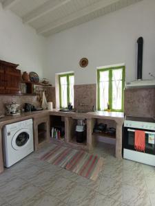 a kitchen with a stove and a washer and dryer at Aegaia Residencies in Katapola