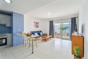 Una cocina y una sala de estar con una mesa y un sofá. en Brisas Chasna 2, en Adeje