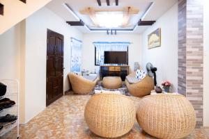 a living room with two chairs and a television at RedDoorz at R2K Pension House in Puerto Princesa City
