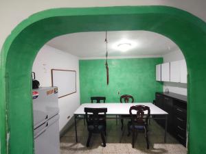 a kitchen with green walls and a table and chairs at Kumho in Medellín