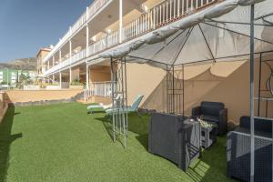 un patio con césped verde en un edificio en Brisas Chasna 2, en Adeje