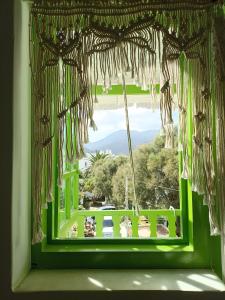 a green window with a view of a yard at Aegaia Residencies in Katapola