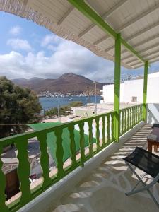 a green balcony with a view of the water at Aegaia Residencies in Katapola