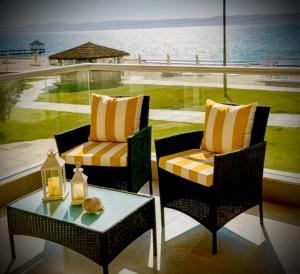 two chairs and a table on a balcony with the ocean at Ocean View Apartment Beach Pools Pier & Lift in Paracas +148 photos