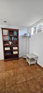 Zimmer mit Bücherregal und Tisch in der Unterkunft La Senda del Lago in Córdoba