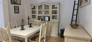 a dining room with a white table and a white cabinet at La Senda del Lago PISCINA PRIVADA in Córdoba