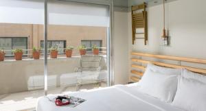 a bedroom with a bed and a balcony with potted plants at Florentin House - By HOMY in Tel Aviv