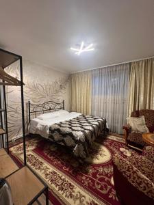 Un dormitorio con una cama, un sofá y una silla. en Golden Rose, en Chişinău